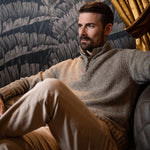 Man wearing Cumberland Donegal Sweater sitting on a sofa