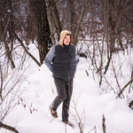 A man wears Pine Peak Down Vest standing in the snow