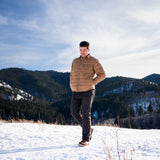 A man wears Pine Peak Down Shirtjac standing in the snow