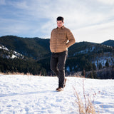 A man wears Pine Peak Down Shirtjac standing in the snow