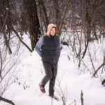 A man wears Pine Peak Down Vest standing in the snow