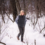 A man wears Pine Peak Down Vest standing in the snow
