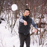 A man wears Pine Peak Down Vest standing in the snow