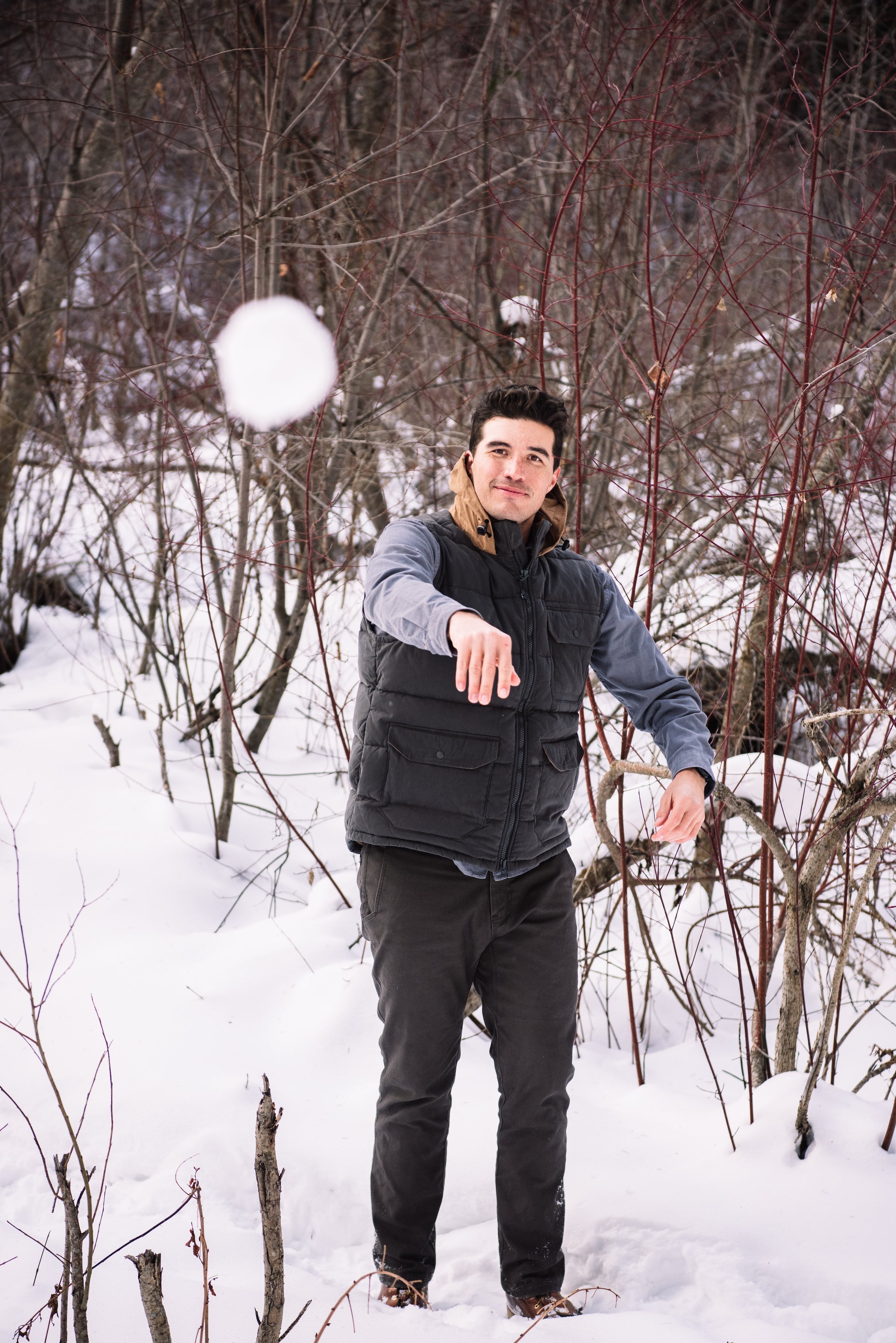A man wears Pine Peak Down Vest standing in the snow