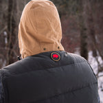 A man wears Pine Peak Down Vest standing in the snow