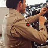 Man weariing Alpine Utility Jacket fixing motorcycle