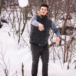 A man wears Pine Peak Down Vest standing in the snow