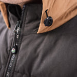 A man wears Pine Peak Down Vest standing in the snow