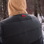 A man wears Pine Peak Down Vest standing in the snow