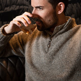 Man wearing Cumberland Donegal Sweater and drinking beverage