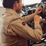 Man weariing Alpine Utility Jacket fixing motorcycle