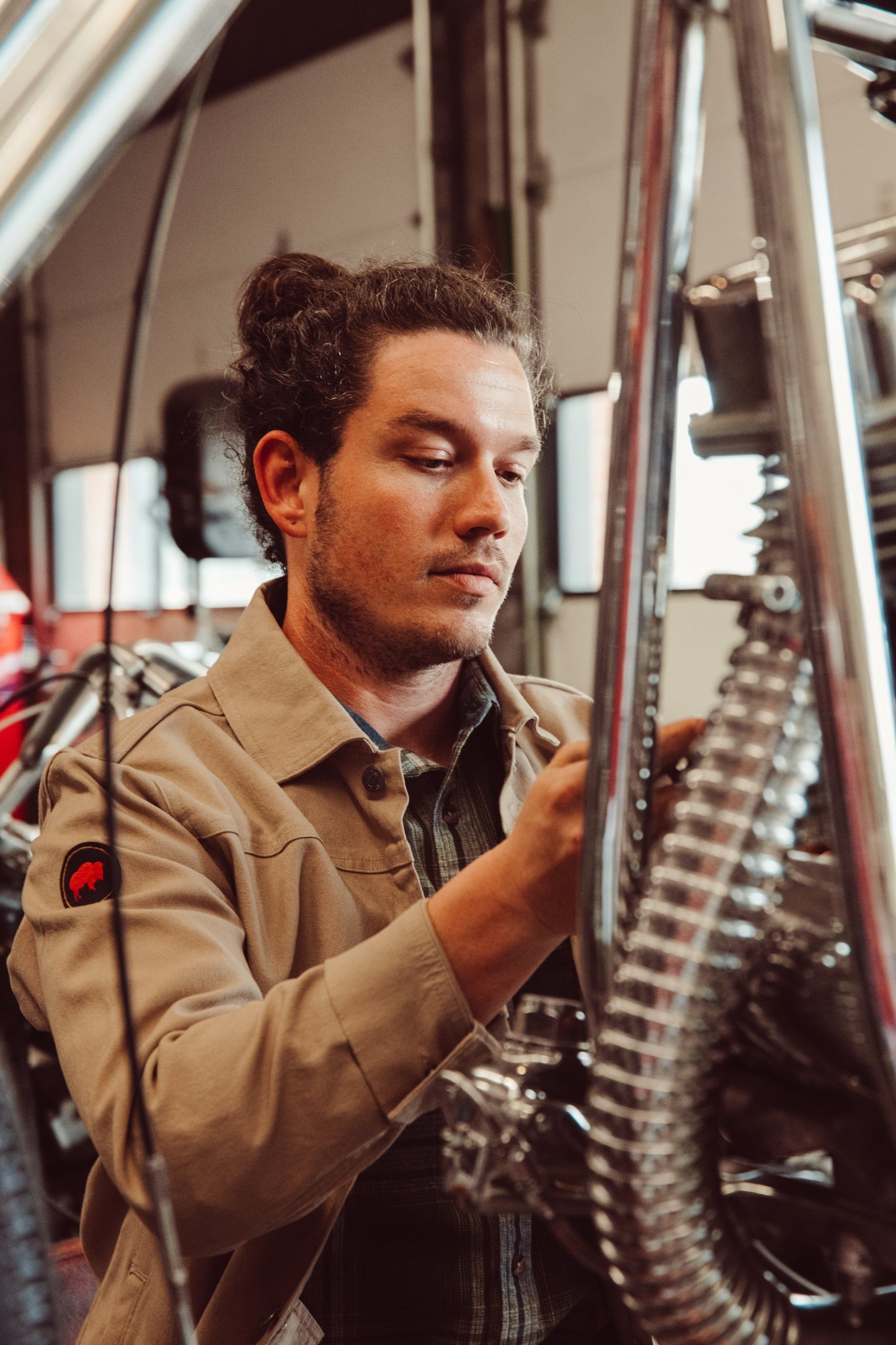 Man wearing Alpine Utility Jacket fixing motorcycle