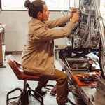 Man wearing Alpine Utility Jacket fixing motocycle